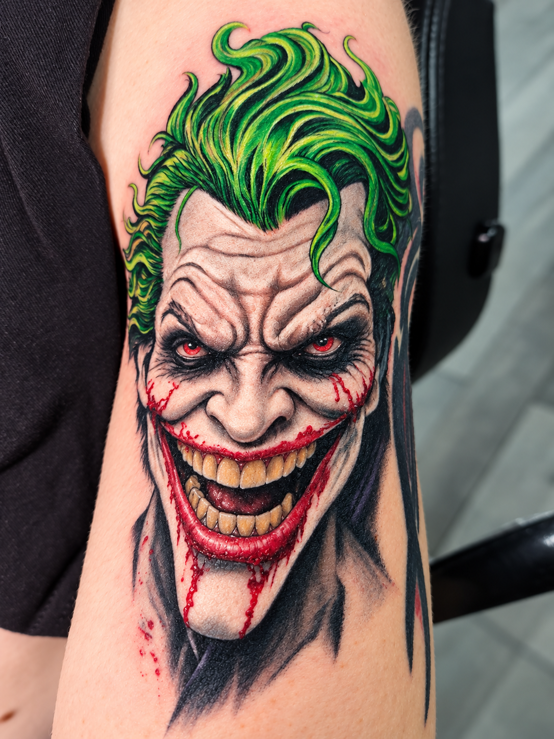 Menacing Joker tattoo concept with green hair and red smile